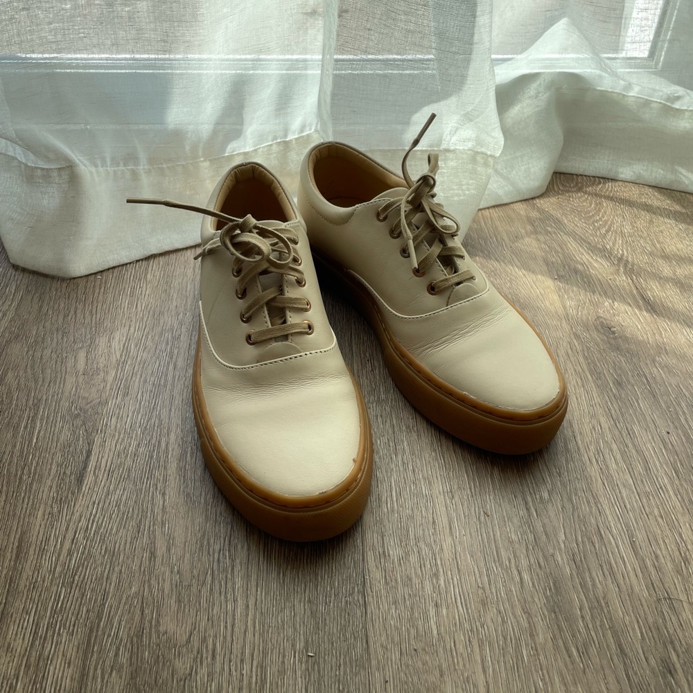 Minimalist cream colored leather sneakers from Nisolo with vibram sole.